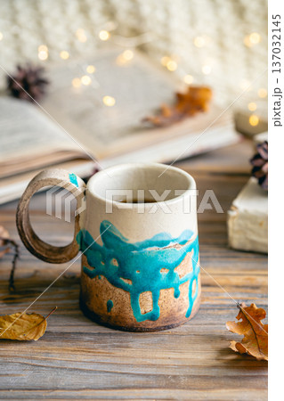 Cozy autumn composition with a handmade cup close-up. Cozy autumn composition with a handmade cup close-up. 137032145