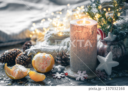 Cozy Christmas composition with a burning candle and decorative details. Cozy Christmas composition with a burning candle and decorative details. 137032168