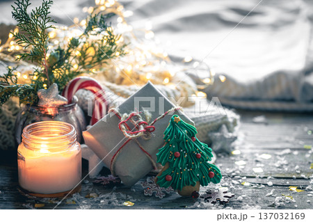 Cozy Christmas composition with a burning candle and decorative details. Cozy Christmas composition with a burning candle and decorative details. 137032169