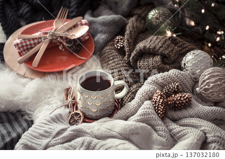 Cozy Christmas morning with cup of tea in bed. Still life scene with sweaters. Steaming cup of hot coffee, tea. Christmas concept. 137032180