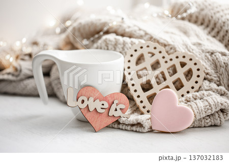 Cozy composition for Valentine's Day with a cup and decor details. Cozy composition for Valentine's Day with a cup and decor details. 137032183