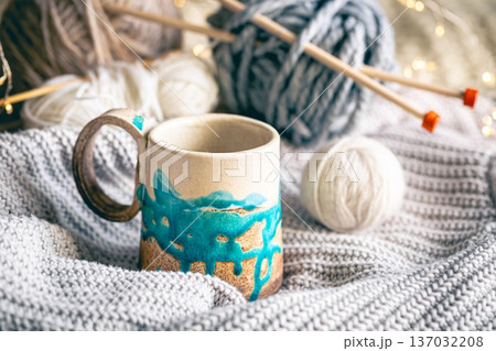 Cozy composition with a cup of coffee, threads and a knitted element. 137032208