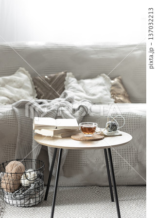 Cozy composition with a cup of tea, a candle and knitted elements. Cozy composition with a cup of tea, a candle and knitted elements. 137032213