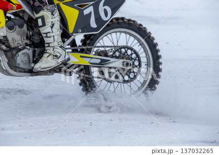 Snow dust rises from back tire Snow dust rises from back tire 137032265