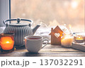 Cozy home composition with a cup of tea, candles and a teapot. 137032291