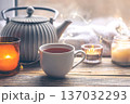 Cozy home composition with a cup of tea, candles and a teapot. 137032293