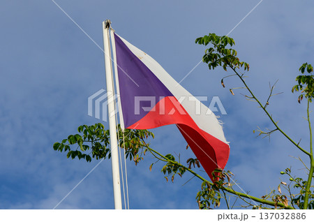 Waving flag of the Czech Republic against a blue sky, symbolizing national pride and heritage in a serene landscape 137032886