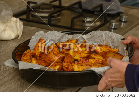 Seasoned Potato Wedges on Parchment Paper Before Baking 137033062