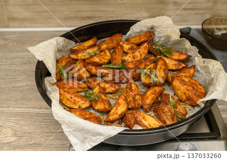 Oven-Roasted Potato Wedges with Rosemary on Rustic Table Oven-Roasted Potato Wedges with Rosemary on Rustic Table 137033260