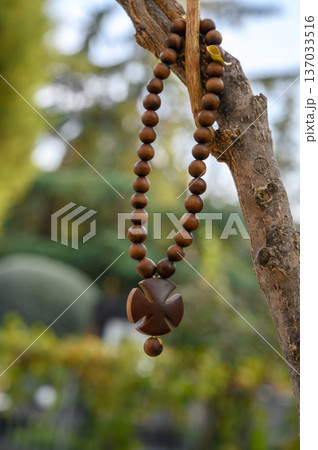Wooden Prayer Beads with Cross Hanging on Cemetery Tree Branch Wooden Prayer Beads with Cross Hanging on Cemetery Tree Branch 137033516