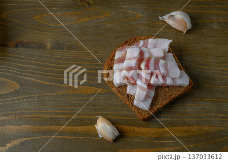 Simple Dark Bread and Salo on Rough Wooden Plank Simple Dark Bread and Salo on Rough Wooden Plank 137033612
