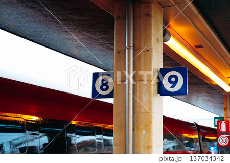 Train platforms numbered eight and nine at a busy train station during the day 137034342