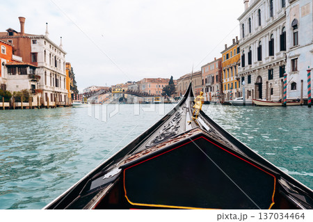 Gondola ride through the canals of Venice during a cloudy afternoon in Italy Gondola ride through the canals of Venice during a cloudy afternoon in Italy 137034464