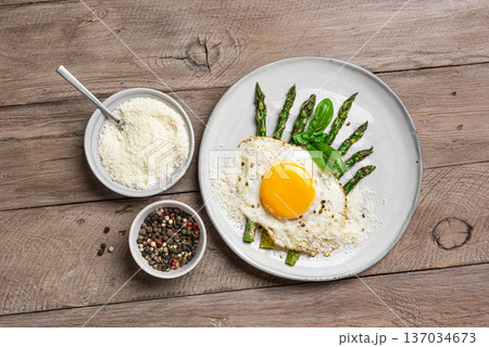 Fried egg with green asparagus and grated parmesan cheese for healthy breakfast 137034673