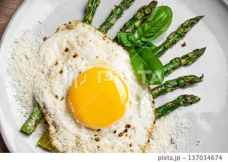 Fried egg with green asparagus and grated parmesan cheese for healthy breakfast Fried egg with green asparagus and grated parmesan cheese for healthy breakfast 137034674