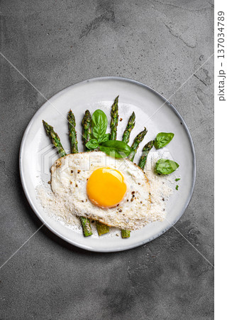 Fried egg with green asparagus and grated parmesan cheese for healthy breakfast Fried egg with green asparagus and grated parmesan cheese for healthy breakfast 137034789