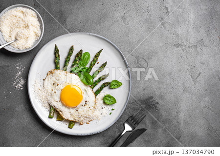 Fried egg with green asparagus and grated parmesan cheese for healthy breakfast Fried egg with green asparagus and grated parmesan cheese for healthy breakfast 137034790