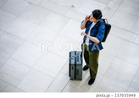 空港で電話と時計確認 ■撮影協力：関西国際空港（KIX） 137035949