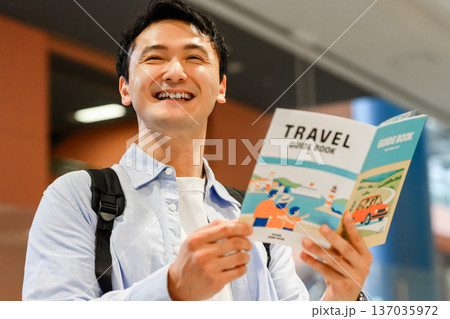 旅行ガイドブックと男性 ■撮影協力:関西国際空港(KIX) 旅行ガイドブックと男性 ■撮影協力:関西国際空港(KIX) 137035972