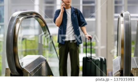 エスカレーターで通話する旅行者 ■撮影協力：関西国際空港（KIX） 137035993
