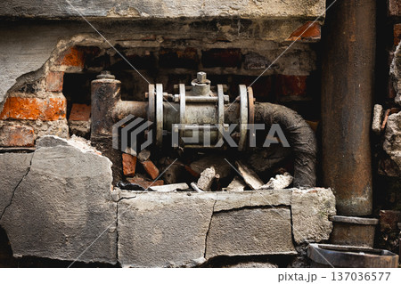 Broken Pipe And Large Shut-Off Valve In Old Wall Broken Pipe And Large Shut-Off Valve In Old Wall 137036577
