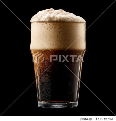 Foamy dark stout beer in a pint glass with creamy foam head, isolated on black background, concept of refreshment and taste 137036798