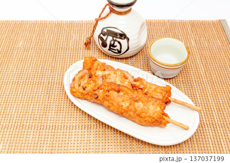 串に刺したサツマ揚げ（イカ、タコ入り）おでん種と日本酒 137037199