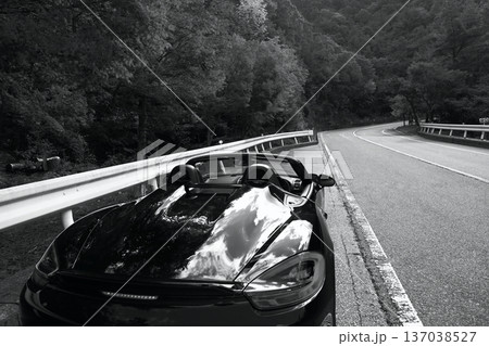 峠道に佇む黒いオープンカー 137038527