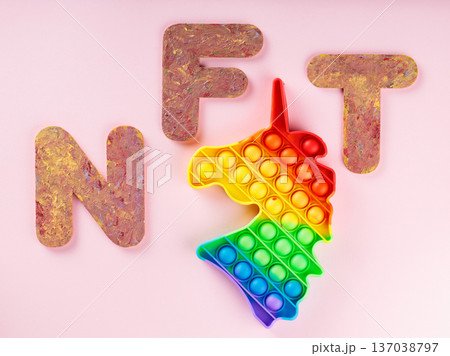 Colorful rainbow gradient fidget toy with NFT letters on pink background for stress relief 137038797
