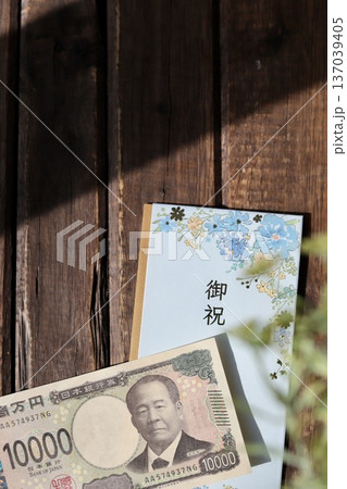 水色で花柄のご祝儀袋と新札の一万円 入学祝や進学祝などの御祝儀 水色で花柄のご祝儀袋と新札の一万円 入学祝や進学祝などの御祝儀 137039405