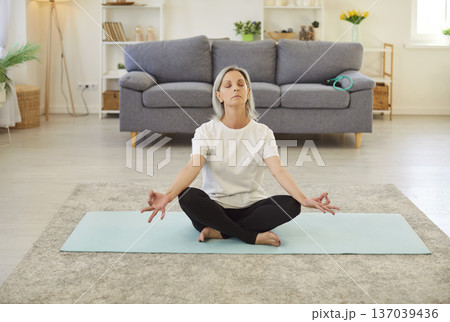 Meditation practice, calm senior woman relax meditating in lotus position, peaceful old yoga home Meditation practice, calm senior woman relax meditating in lotus position, peaceful old yoga home 137039436