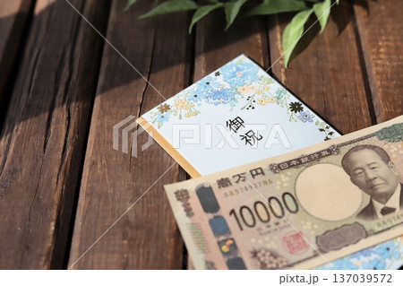 水色で花柄のご祝儀袋と新札の一万円　入学祝や進学祝などの御祝儀 137039572