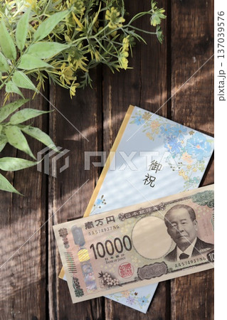 水色で花柄のご祝儀袋と新札の一万円 入学祝や進学祝などの御祝儀 水色で花柄のご祝儀袋と新札の一万円 入学祝や進学祝などの御祝儀 137039576