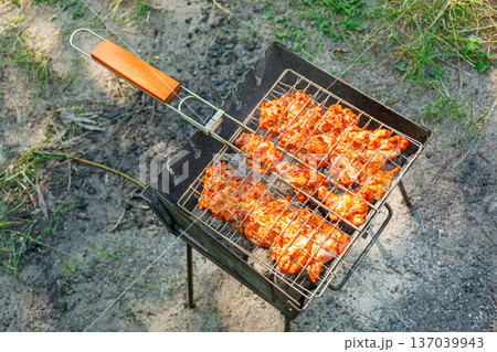 Cooking chicken wings and legs on the grill. Roasted meat on the grill 137039943