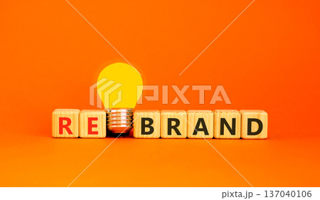 Rebrand and brand symbol. The concept word Rebrand on wooden cubes. Beautiful orange background. Beautiful yellow light bulb. Copy space. Business rebrand and brand concept. Rebrand and brand symbol. The concept word Rebrand on wooden cubes. Beautiful orange background. Beautiful yellow light bulb. Copy space. Business rebrand and brand concept. 137040106