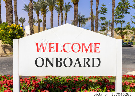 Welcome onboard symbol. Concept words Welcome onboard on beautiful big white road sign. Beautiful blue sky palm trees background. Business, motivational welcome onboard concept. Copy space. Welcome onboard symbol. Concept words Welcome onboard on beautiful big white road sign. Beautiful blue sky palm trees background. Business, motivational welcome onboard concept. Copy space. 137040260