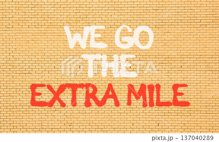 Support, help we go the extra mile symbol. Concept words We go the extra mile on beautiful brown brick wall. Beautiful brick wall background. Business we go the extra mile concept. Copy space. 137040289