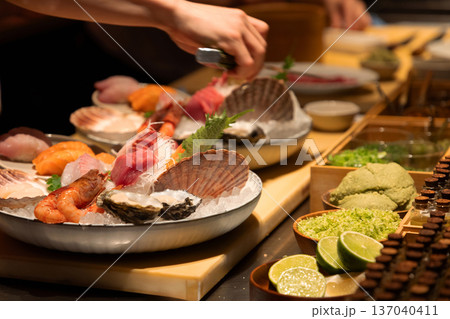 Fresh sushi platter with assorted seafood and garnishes on wooden table Fresh sushi platter with assorted seafood and garnishes on wooden table 137040411