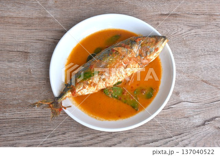 spicy boiled mackerel topping chop lemon grass in red curry sauce on plate  137040522