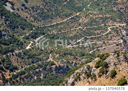 Winding mountain road through the hills of Crete, Greece under the bright sun Winding mountain road through the hills of Crete, Greece under the bright sun 137040578