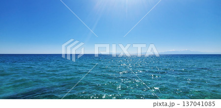 The clear turquoise water of a warm sea under a clear blue sky The clear turquoise water of a warm sea under a clear blue sky 137041085