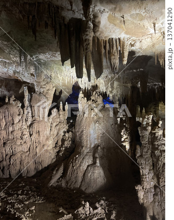 Majestic stalactites and stalagmites in illuminated underground cave 137041290
