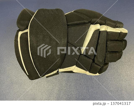 a hockey glove on the floor in a sports locker room 137041317