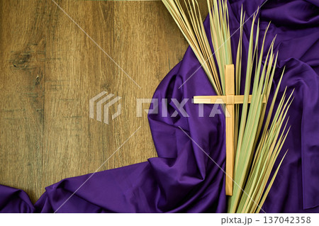 Palm sunday cross and fronds on purple fabric 137042358