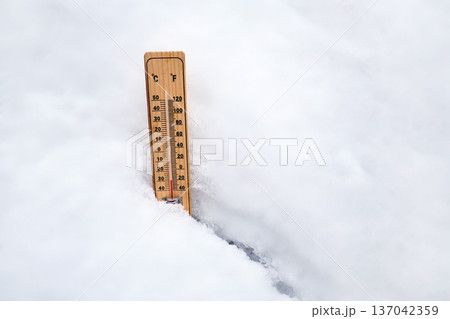 Thermometer showing freezing temperatures in fresh snow Thermometer showing freezing temperatures in fresh snow 137042359