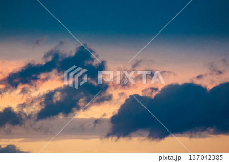 dramatic storm sky with clouds at sunset. dark blue cloudy background at dusk. bad weather forecast during spring. deep moody tones. meteorology air pressure change. gloomy atmosphere 137042385
