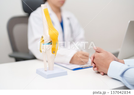Doctor with Human Knee joint anatomy model. Osteoarthritis, Patellofemoral Pain Syndrome, Patellar Tendinitis, ACL, Anterior Cruciate Ligament, PCL, Posterior, MCL, Medial Collateral, LCL and Lateral Doctor with Human Knee joint anatomy model. Osteoarthritis, Patellofemoral Pain Syndrome, Patellar Tendinitis, ACL, Anterior Cruciate Ligament, PCL, Posterior, MCL, Medial Collateral, LCL and Lateral 137042834