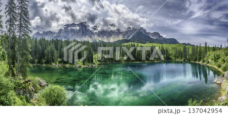 The emerald green Lake Carezza reflecting Latemar mountain, Dolomites, Italy The emerald green Lake Carezza reflecting Latemar mountain, Dolomites, Italy 137042954