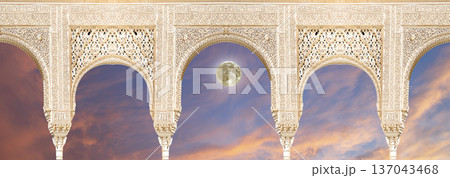 Arches in Islamic (Moorish)  style (against the sunset and supermoon) in Alhambra, Granada, Spain 137043468