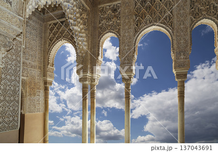 Arches in Islamic (Moorish) style (against the background of a beautiful sky with clouds) in Alhambra, Granada, Spain 137043691